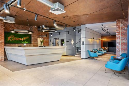 a lobby with a bar and blue chairs at Roomzzz Newcastle City in Newcastle upon Tyne
