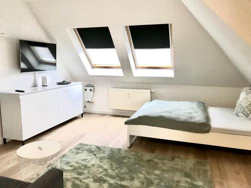 ein Schlafzimmer mit einem Bett und zwei Oberlichtern in der Unterkunft Helles und ruhiges Apartment direkt am Flughafen Leipzig Halle in Schkeuditz