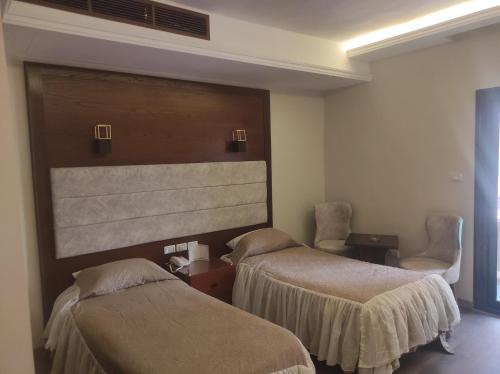 une chambre d'hôtel avec deux lits et deux chaises dans l'établissement Beirut Hotel Cairo, au Caire