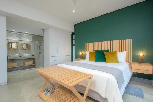 una camera da letto con un grande letto con una parete verde di Kruger's Keep - Luxury Couples Haven a Marloth Park