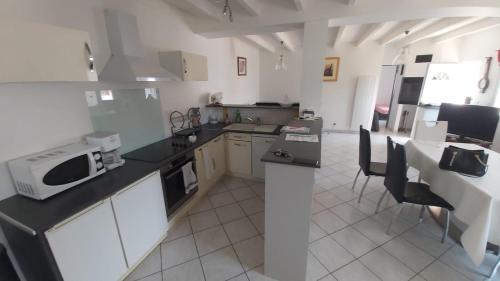 une cuisine avec un micro-ondes et un plan de travail dans l'établissement Agréable maison spacieuse à la Tremblade, à La Tremblade