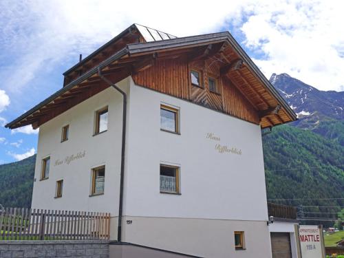 a building with a wooden roof on top of it at Appartement Rifflerblick in Pettneu am Arlberg