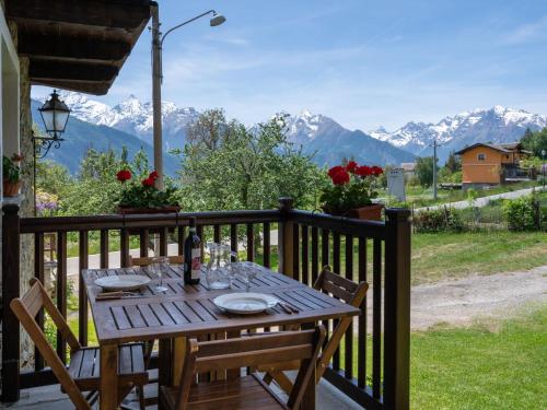 a wooden table on a balcony with a view of mountains at Apartment Ville sur Sarre by Interhome in Sarre