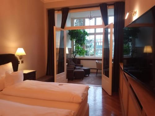 una camera d'albergo con letto e soggiorno di Hotel Hollerbusch a Weimar