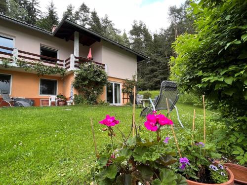 a house with pink flowers in a yard at Apartment Keutschach by Interhome in Keutschach am See