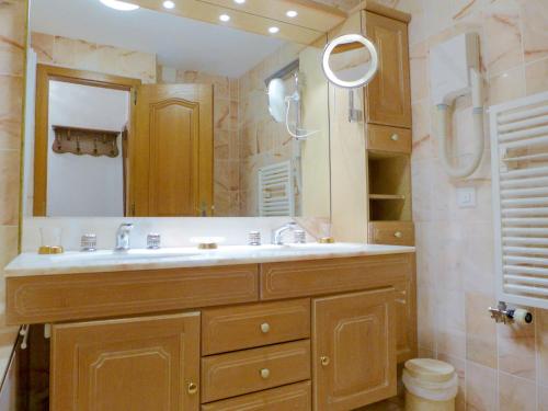 a bathroom with a sink and a large mirror at Apartment Terrasse Des Alpes 708 by Interhome in Vermala