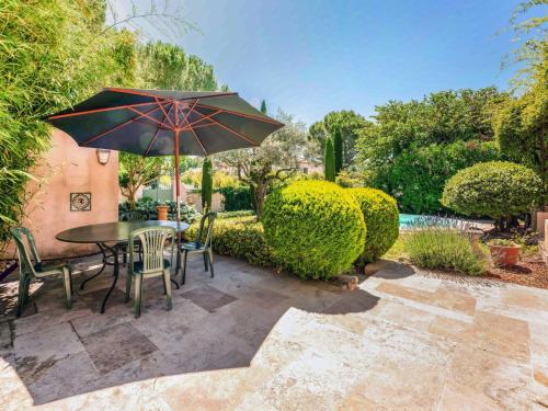 un patio avec une table, des chaises et un parasol dans l'établissement Holiday Home La Noria by Interhome, à Carpentras