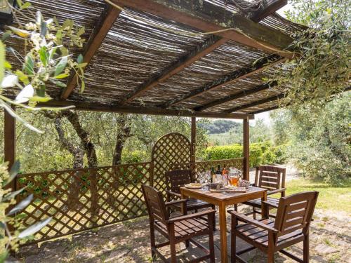 a wooden table and chairs under a wooden pergola at Apartment Le Buche-4 by Interhome in Monsanto