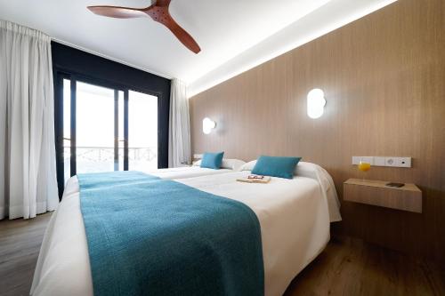a bedroom with two beds and a large window at Hotel Parque La Paz in Playa de las Americas
