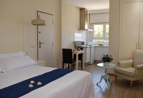 チクラナ・デ・ラ・フロンテーラにあるAparthotel Novo Sancti Petriのベッドとキッチン付きのホテルルーム