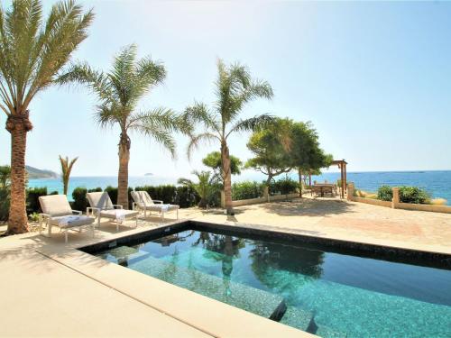 a swimming pool with palm trees and the ocean at Holiday Home Casa Taty by Interhome in Villajoyosa
