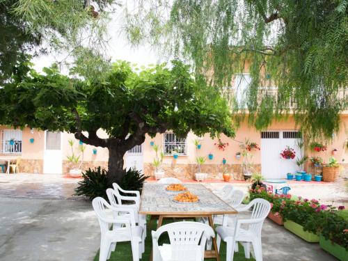 stół i krzesła pod drzewem na dziedzińcu w obiekcie Holiday Home Masia del Mosso by Interhome w mieście Camarles