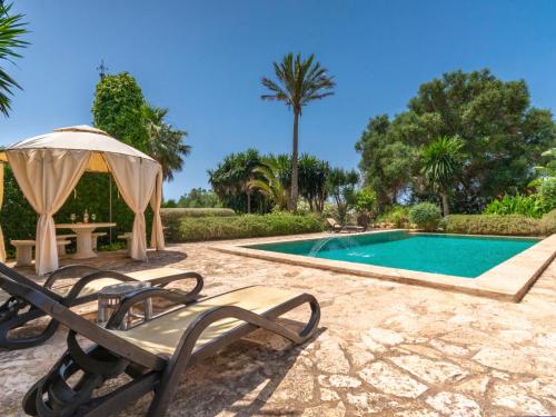 a swimming pool with a chair and an umbrella at Holiday Home Moli de Son Vidal by Interhome in Santanyi
