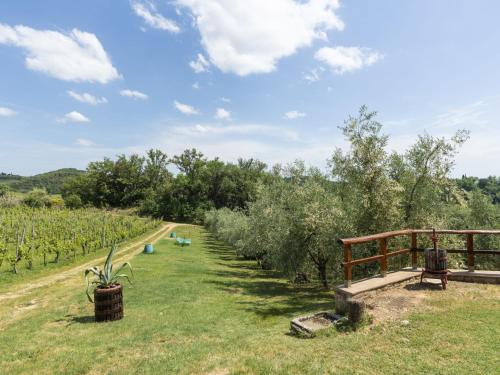 a garden with a row of trees and a fence at Apartment Ciliegio by Interhome in Monsanto