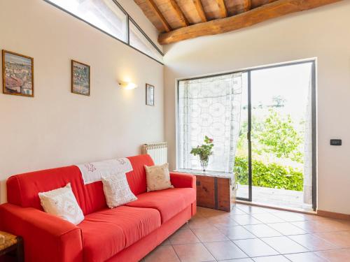 a red couch in a living room with a large window at Apartment Ciliegio by Interhome in Monsanto