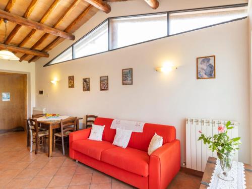a living room with a red couch and a table at Apartment Ciliegio by Interhome in Monsanto