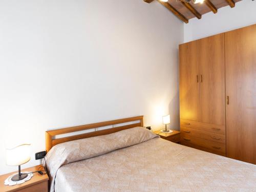 a bedroom with a bed and a wooden cabinet at Apartment Ciliegio by Interhome in Monsanto