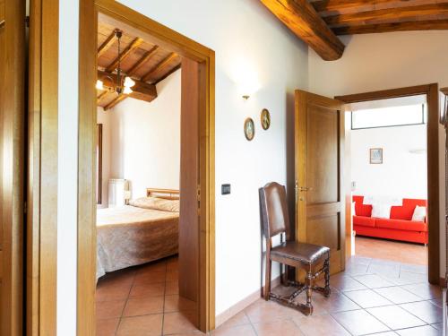 a bedroom with a bed and a chair in a room at Apartment Ciliegio by Interhome in Monsanto