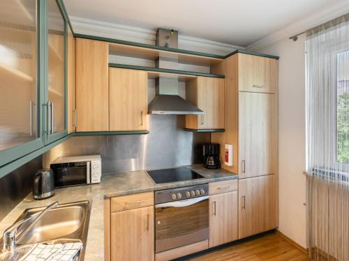 滨湖采尔斯坦萨里公寓的配有木制橱柜和水槽的厨房