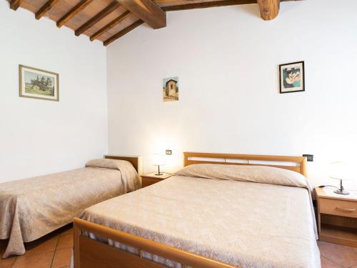 two beds in a bedroom with white walls and wooden ceilings at Apartment Ciliegio by Interhome in Monsanto
