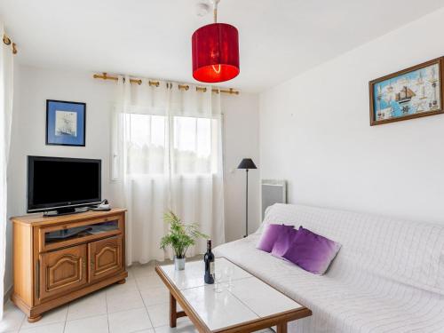 ein Wohnzimmer mit einem weißen Sofa und einem TV in der Unterkunft Holiday Home Ty Fañch - KER227 by Interhome in Kerlouan
