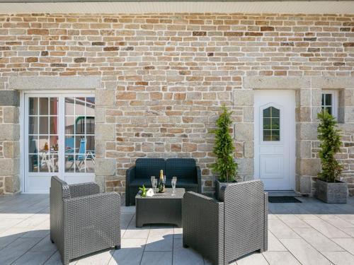 d'une terrasse avec 2 chaises, une table et un mur en briques. dans l'établissement Holiday Home Villa Mor-Eol - PNR211 by Interhome, à Plounéour-Trez