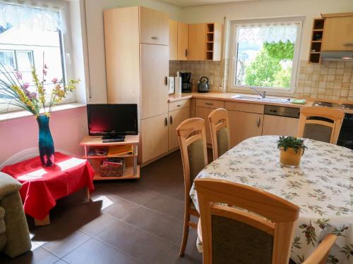 a kitchen with a table and chairs and a television at Apartment Hoch by Interhome in Neukirch