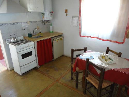 uma cozinha com um fogão e uma mesa com uma toalha de mesa em Las Cuatro Estaciones em São Rafael