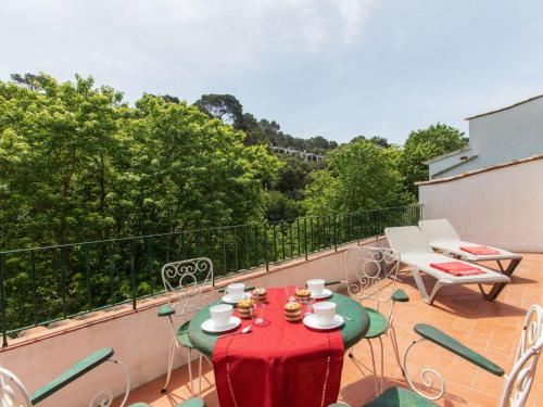 a table with a red table cloth on a balcony at Apartment S'Esquirols III by Interhome in Begur