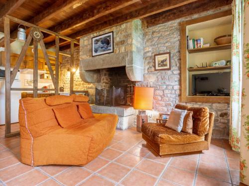 a living room with two chairs and a stone fireplace at Holiday Home La Haute Gilberdière - SIY400 by Interhome in Sartilly