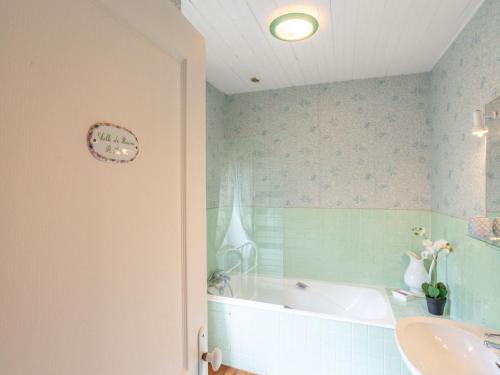 a bathroom with a bath tub and a sink at Holiday Home La Haute Gilberdière-1 by Interhome in Sartilly