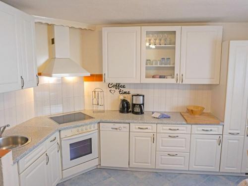 eine weiße Küche mit weißen Schränken und einem Waschbecken in der Unterkunft Apartment Föhrenheim - SFE201 by Interhome in Leutasch