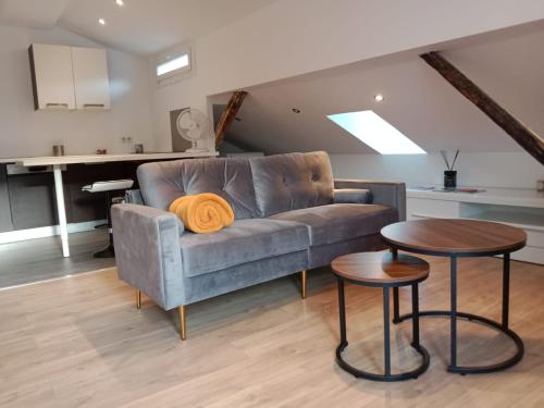 Una sala de estar con un sofá y dos mesas. en Beau T2 sur le vieux port, centre de Bastia, en Bastia