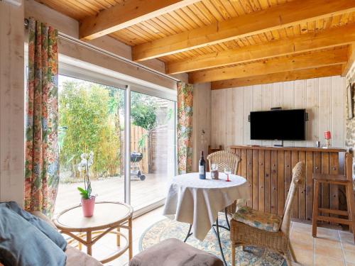 uma sala de estar com uma mesa e uma televisão em Holiday Home Les Bambous - GUI110 by Interhome em Guissény