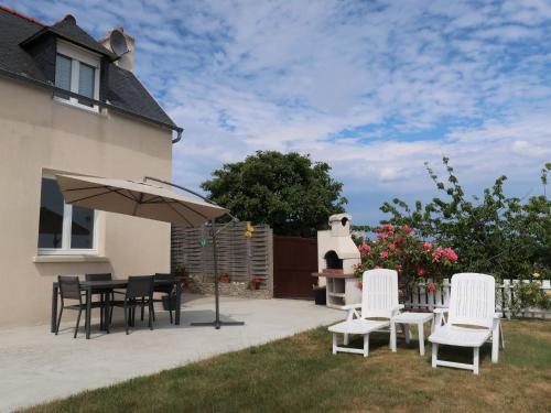 a patio with a table and chairs and an umbrella at Holiday Home Le Sémaphore by Interhome in Pleubian