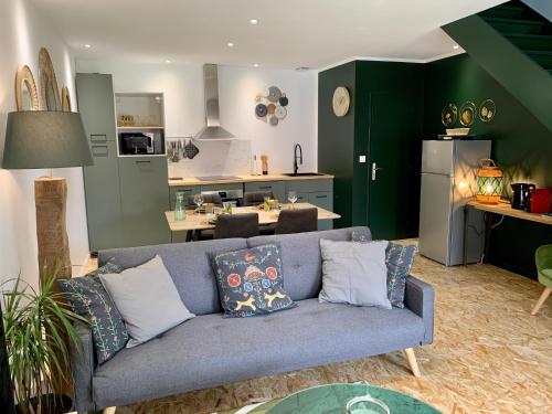 uma sala de estar com um sofá azul e uma cozinha em Domaine de la Jarrige em Saint-Vaury
