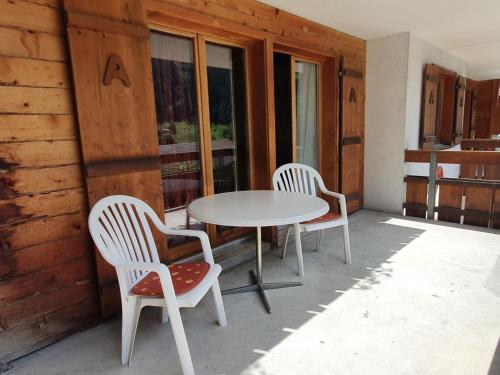 two chairs and a table on a porch at Apartment Chalet Abendrot-21 by Interhome in Grindelwald
