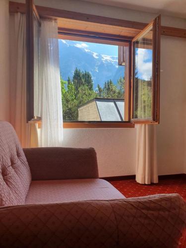 - un salon avec une grande fenêtre et un canapé dans l'établissement Apartment Chalet Abendrot-27 by Interhome, à Grindelwald