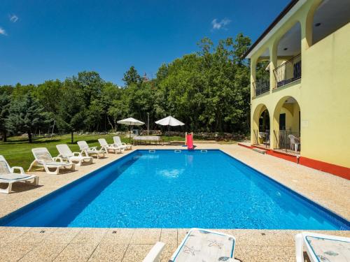 a swimming pool with chairs and a house at Holiday Home Villa Tanne - LBN427 by Interhome in Labin