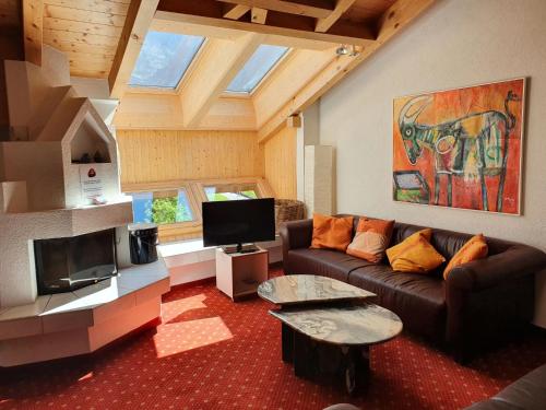 a living room with a couch and a tv at Apartment Chalet Abendrot-19 by Interhome in Grindelwald