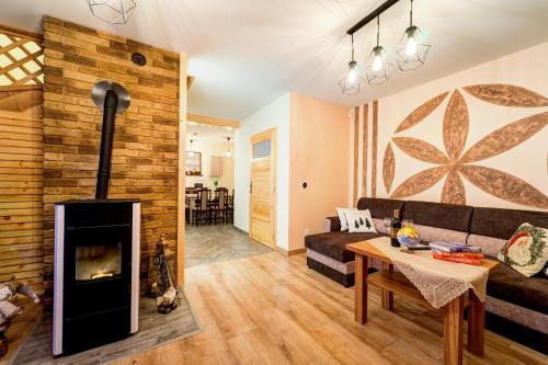a living room with a couch and a fireplace at Komfortowe domki na wynajem - Holiday Tatry in Poronin