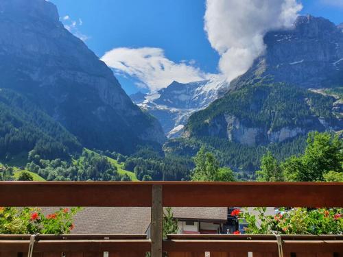 uma vista para um vale montanhoso a partir de um banco em Apartment Chalet Abendrot-7 by Interhome em Grindelwald