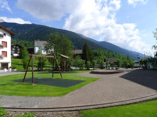 a park with a swing set in the grass at Apartment Apt B 027 by Interhome in Disentis