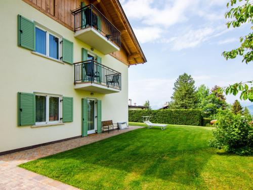 a house with green shutters and a yard at Apartment Pensione Villa Belfiore-1 by Interhome in Ronzone