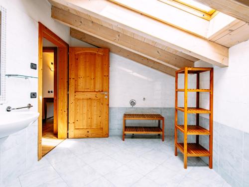 a bathroom with a wooden door and a sink at Apartment Pensione Villa Belfiore-1 by Interhome in Ronzone