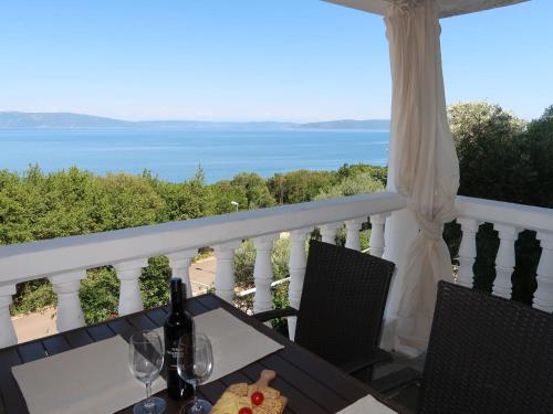 a table with wine glasses and a view of the ocean at Apartment Ulika - LBN105 by Interhome in Ravni