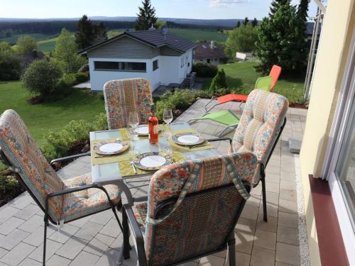 une table et des chaises assises sur une terrasse dans l'établissement Holiday Home Mily by Interhome, à Dittishausen