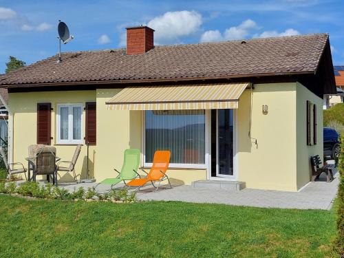 a yellow house with chairs sitting on a patio at Holiday Home Mily by Interhome in Dittishausen