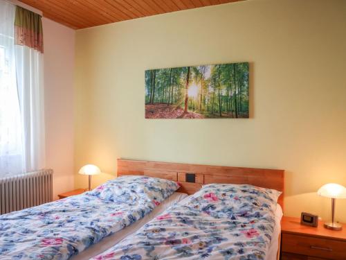 a bedroom with a bed and two lamps and a painting on the wall at Holiday Home Mily by Interhome in Dittishausen