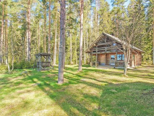 eine Blockhütte mit einem Pavillon in einem Wald in der Unterkunft Holiday Home Kuusela by Interhome in Soini
